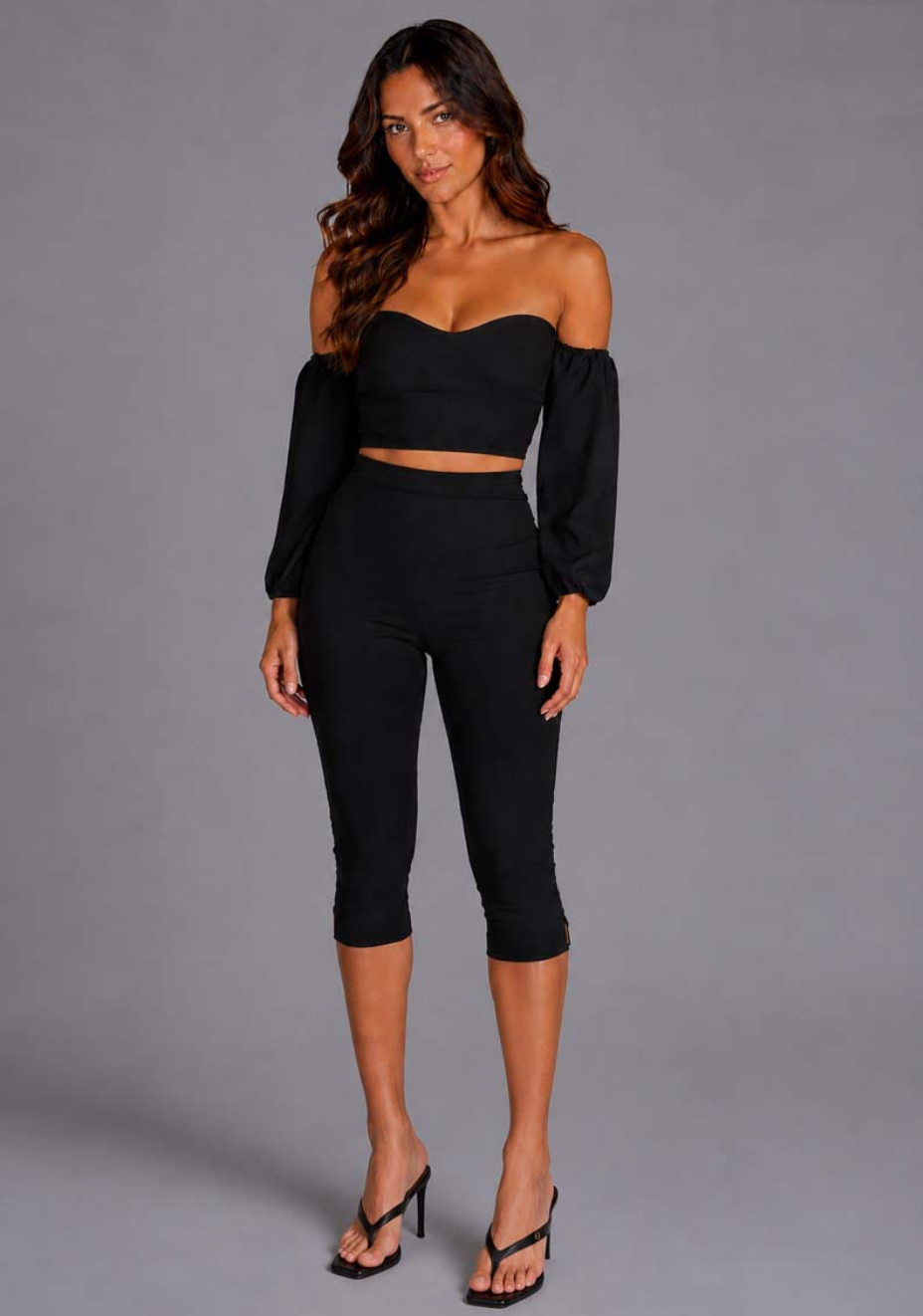 Front image of the VSPR Belle Black Top showcasing the sculpted sweetheart neckline, voluminous sleeves, and flattering body-hugging fit, standing against a grey studio backdrop.