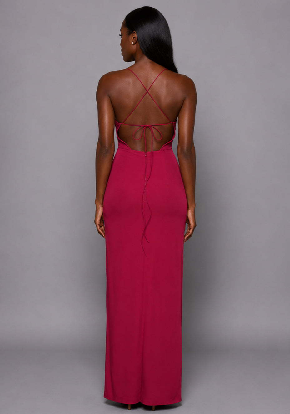 Back image of a model wearing the VSPR Maggie Sweetheart Neckline Raspberry Maxi Dress, featuring an elegant criss-cross tie back and flowing maxi-length silhouette against a grey studio backdrop.