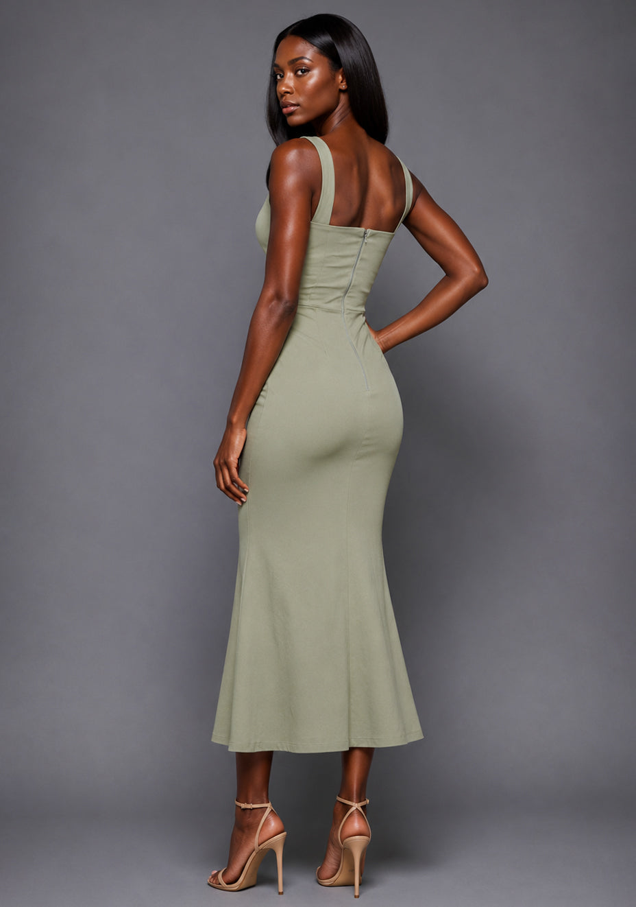 Side-back image of a model wearing the VSPR Marianna Square Neckline Fishtail Olive Midaxi Dress, highlighting the figure-enhancing fit and flowing fishtail hem against a grey studio backdrop.