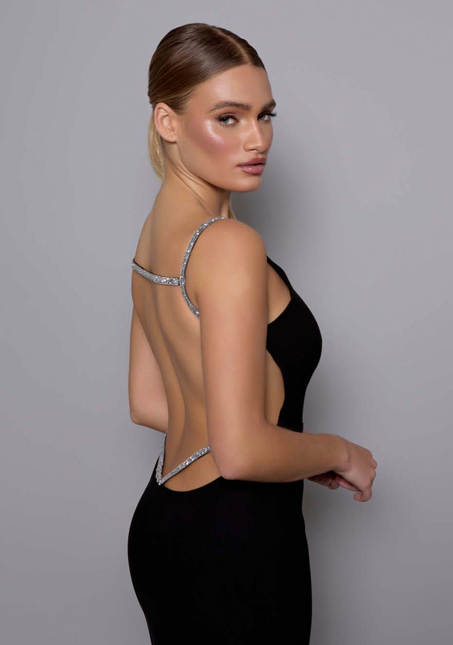 Close-up of the VSPR Alba dress from the side-back angle, emphasizing the shimmering silver crystal straps and open-back detailing with structured fabric lines.