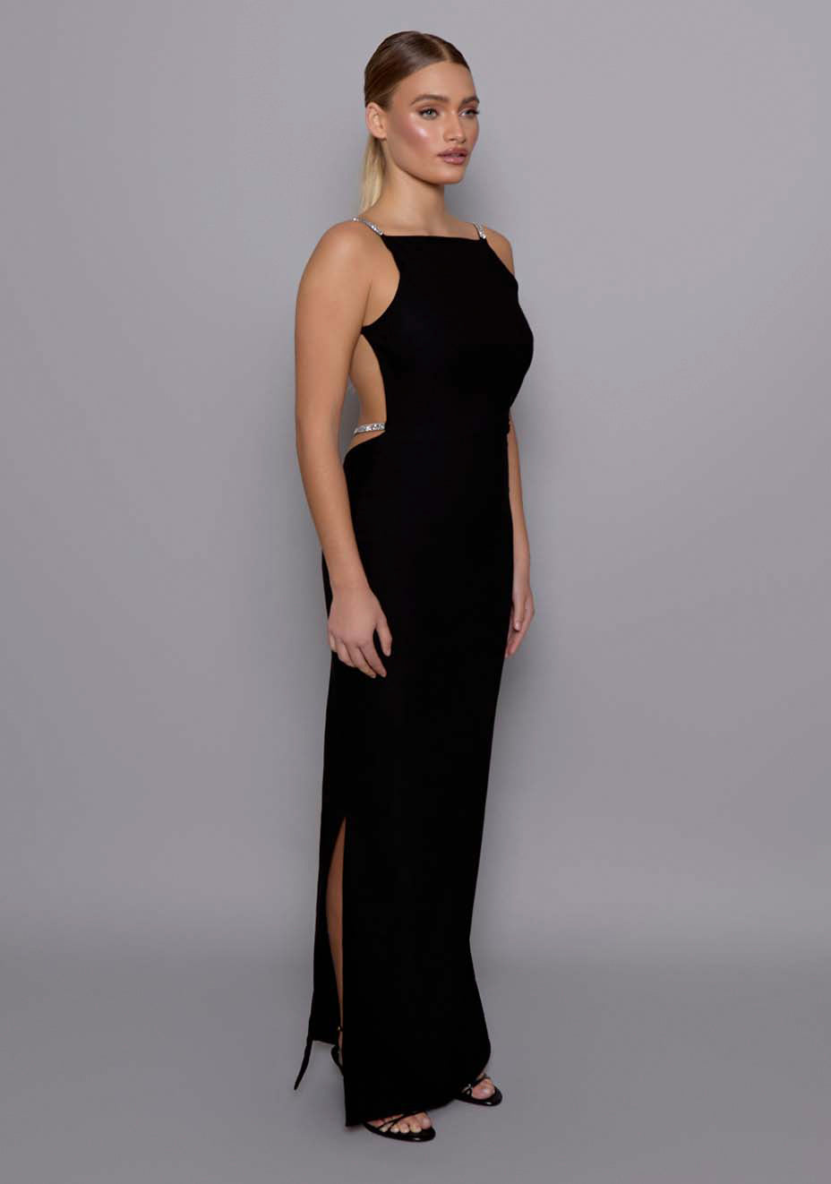 Side-front view of the VSPR Alba black gown revealing the elegant profile, square neckline, and sculpted waistline with clean, elongating lines