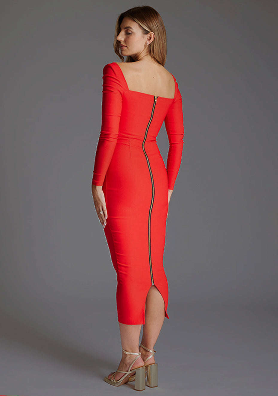 Side back image of a model wearing the Vesper Amy Sweetheart Neckline Long Sleeve Midaxi Dress in Red, highlighting the sleek fit, subtle curve-hugging shape, and elegant midaxi hem.