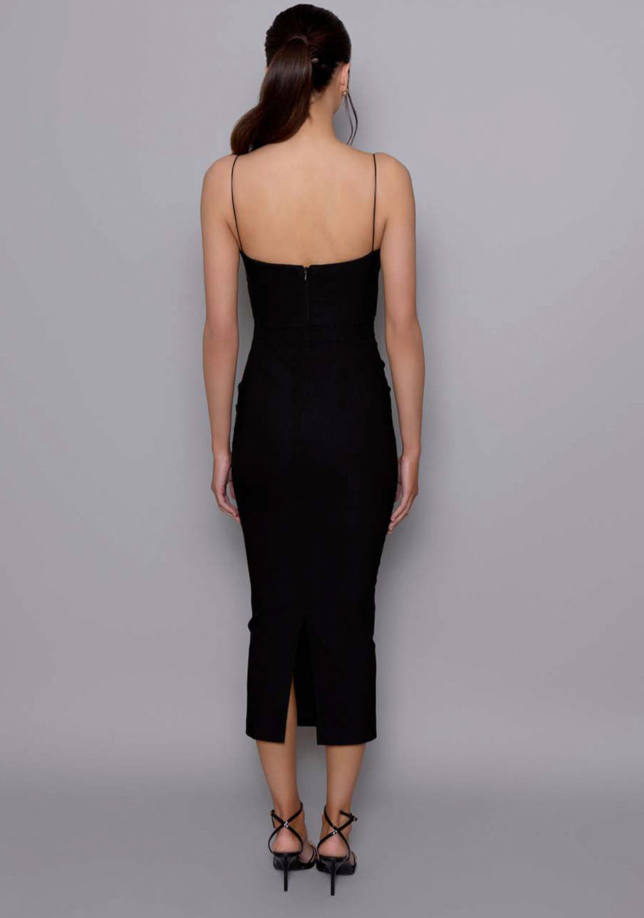 Rear view of the VSPR Angelina dress with thin delicate straps, centre-back zip, and rear split hem, highlighting the sculpted fit and open-back design.