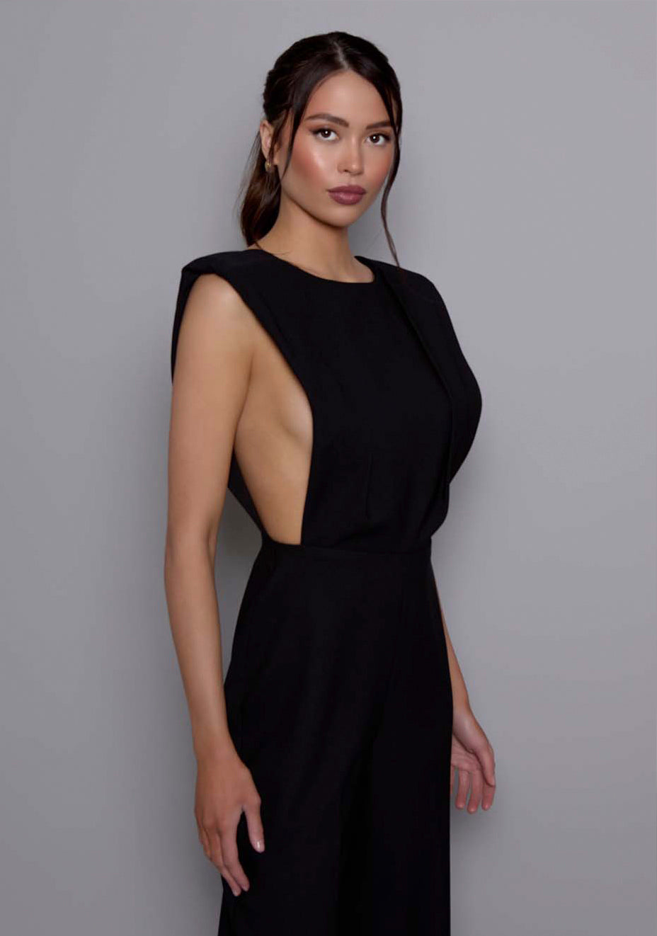 Close-up side front of the VSPR Bronte Jumpsuit showcasing the softly structured fabric, sculptural bodice, and precise tailoring details at the front.