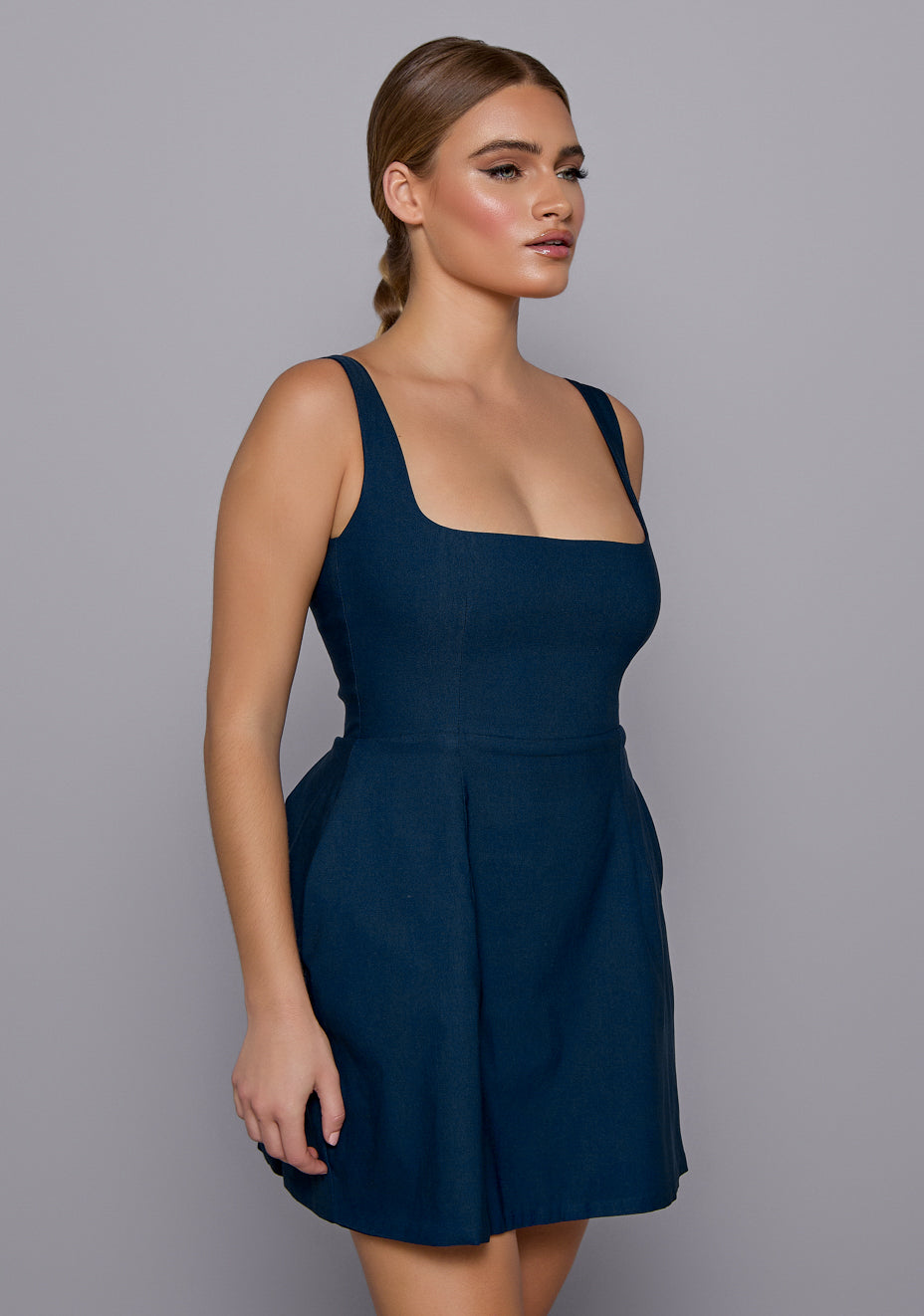 Close-up side-front view of the VSPR Camille Dress focusing on the square neckline, structured bodice, and soft flare starting at the waist.
