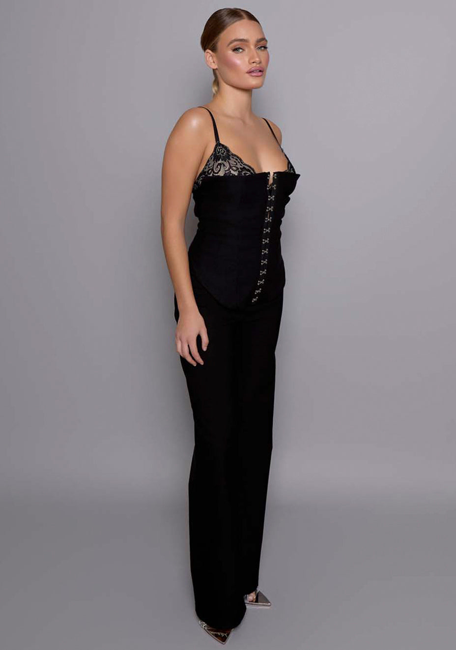 Side-front view of the VSPR Cassia black basque highlighting the corset-inspired silhouette, contoured bodice, and softly squared neckline framing the bust.