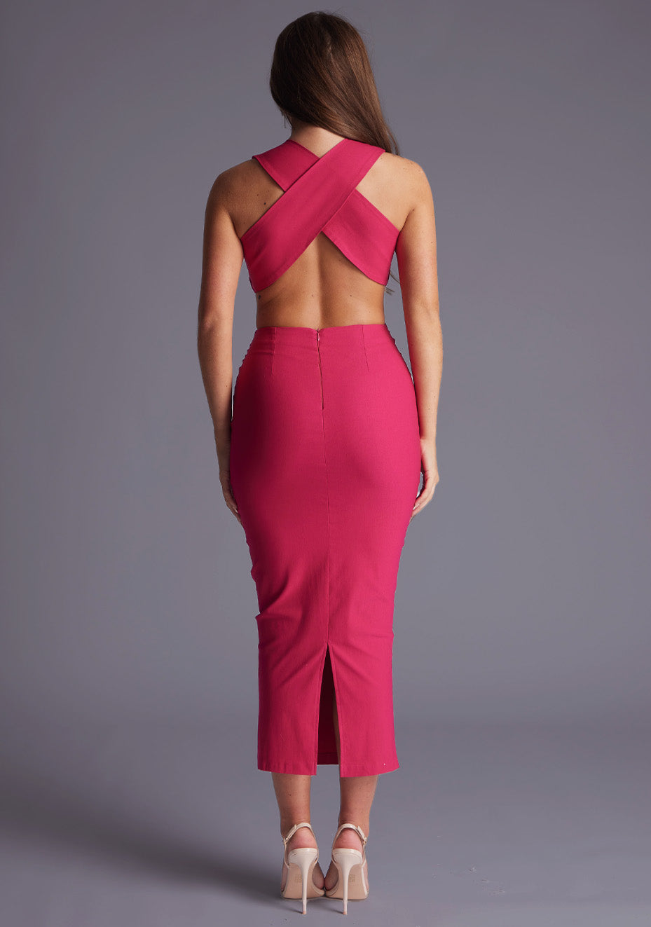 Back image of a model wearing the Vesper Cherry Plunge Midaxi Dress in Cerise, showcasing the crisscross open back and streamlined bodycon silhouette.
