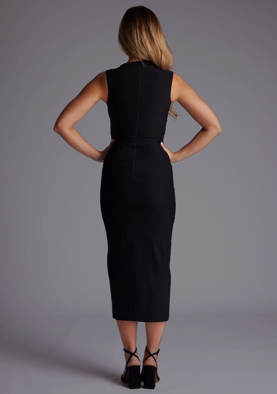 Back image of a model wearing the Vesper Clarice High Neck Ruched Midaxi Dress in Black, featuring a sleek sleeveless design and figure-contouring bodycon fit.