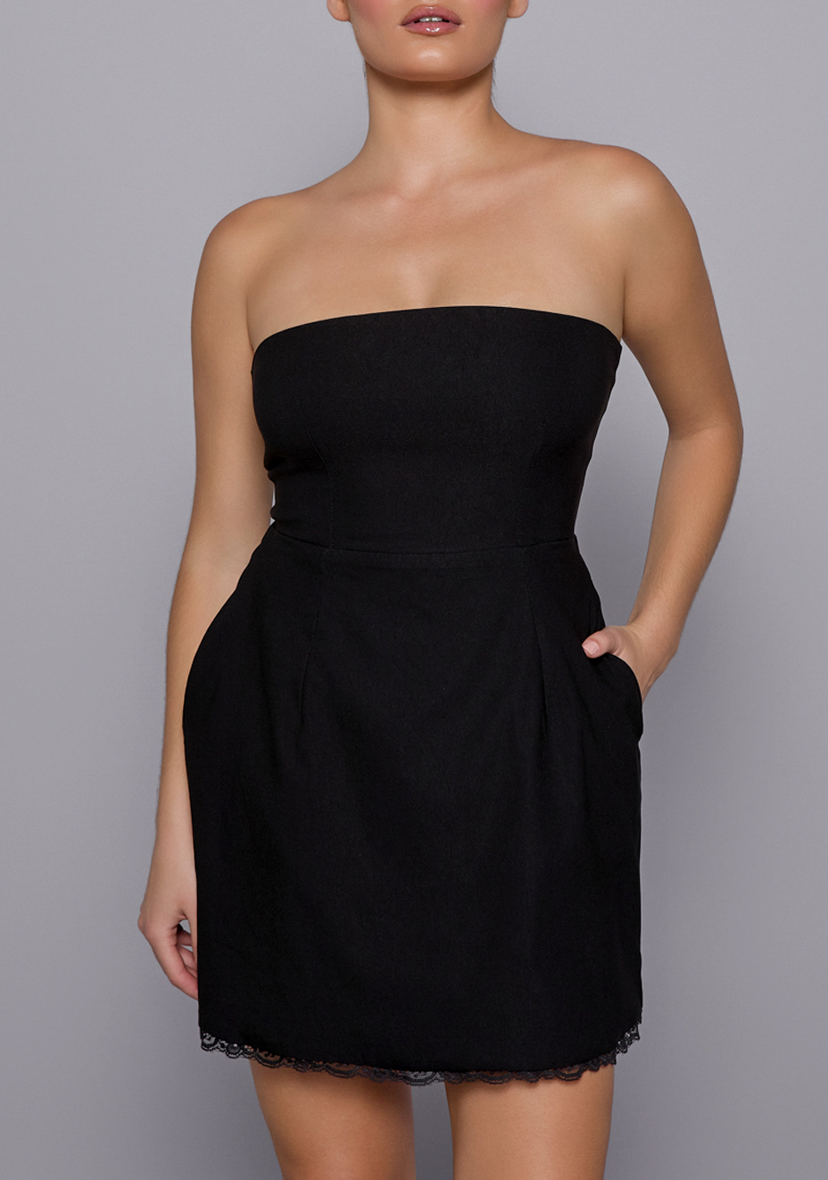 Close-up of the VSPR Emily Dress showing the scalloped lace trim along the hem and smooth sculpting fabric, highlighting its feminine detailing and texture.