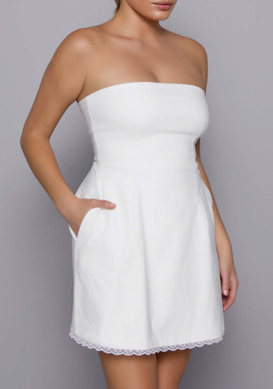 Close-up of the VSPR Emily Mini Dress from the side front, showcasing the sculpted strapless neckline and smooth fabric leading into the flared skirt.