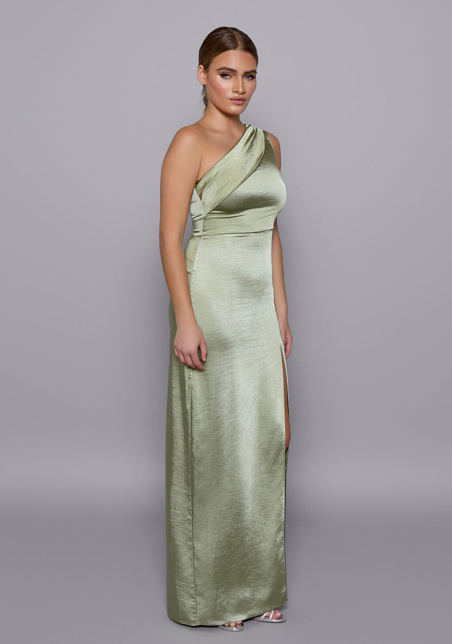 Side-front view of the VSPR Fliss Olive Satin Dress showcasing the sculpted one-shoulder silhouette, high leg slit, and body-skimming fit.
