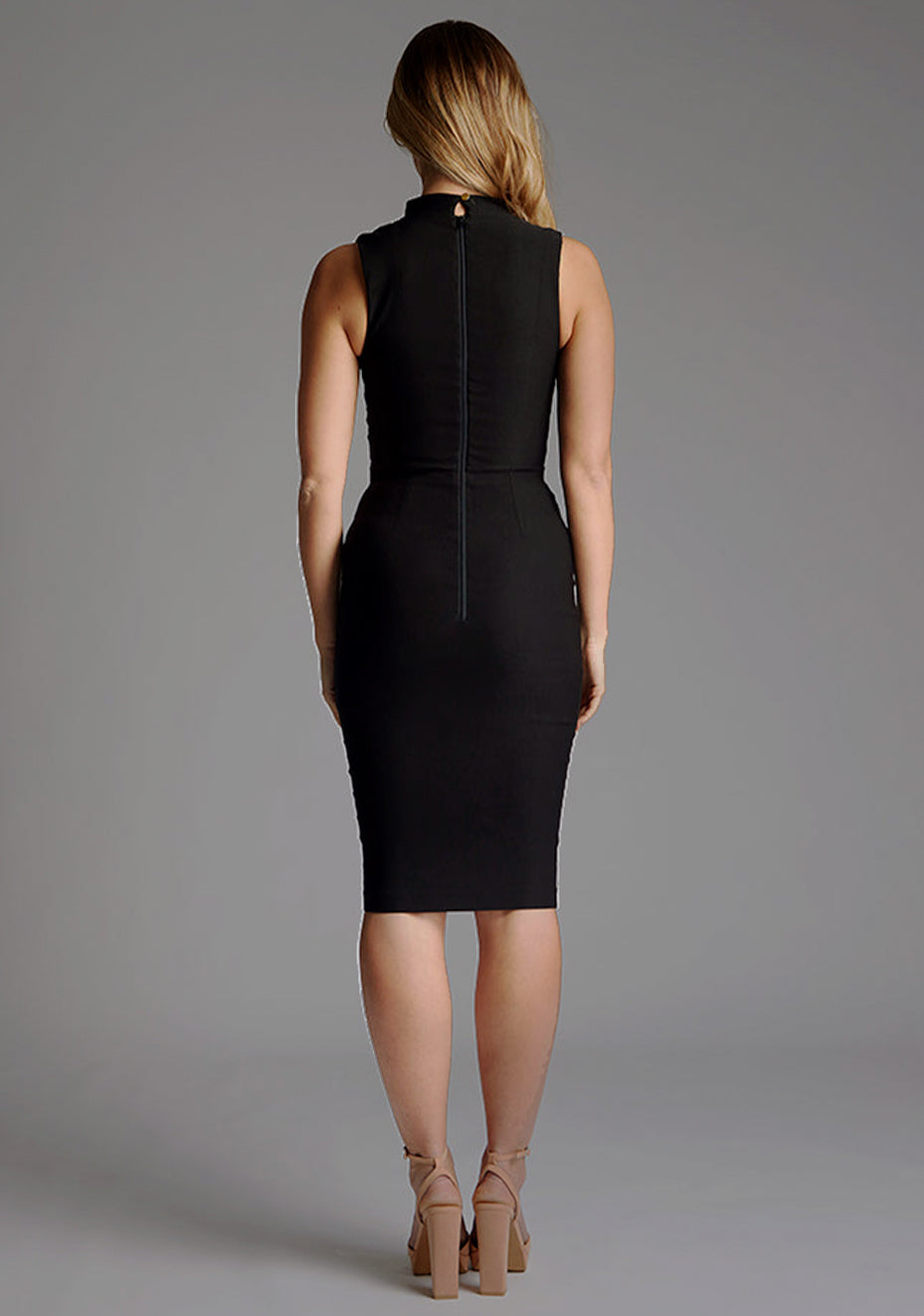Back image of a model wearing black midi dress with a high neck and a subtle front cut-out, this dress exudes refined style. The designed featured is the Vesper Jacqueline High Neck Midi Dress in Black.