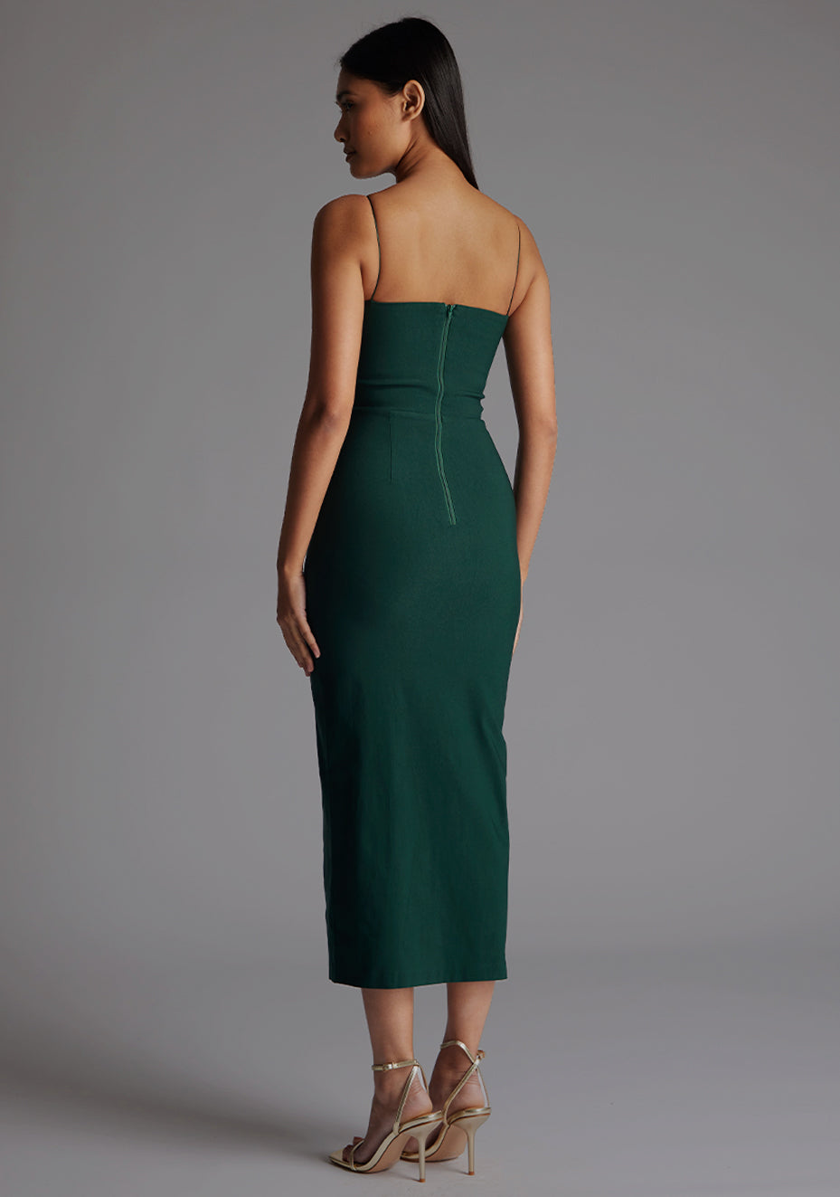 Side back image of a model wearing the Vesper Katie Strap Detail Midaxi Dress in Forest Green, showing the streamlined fit and clean strap lines.