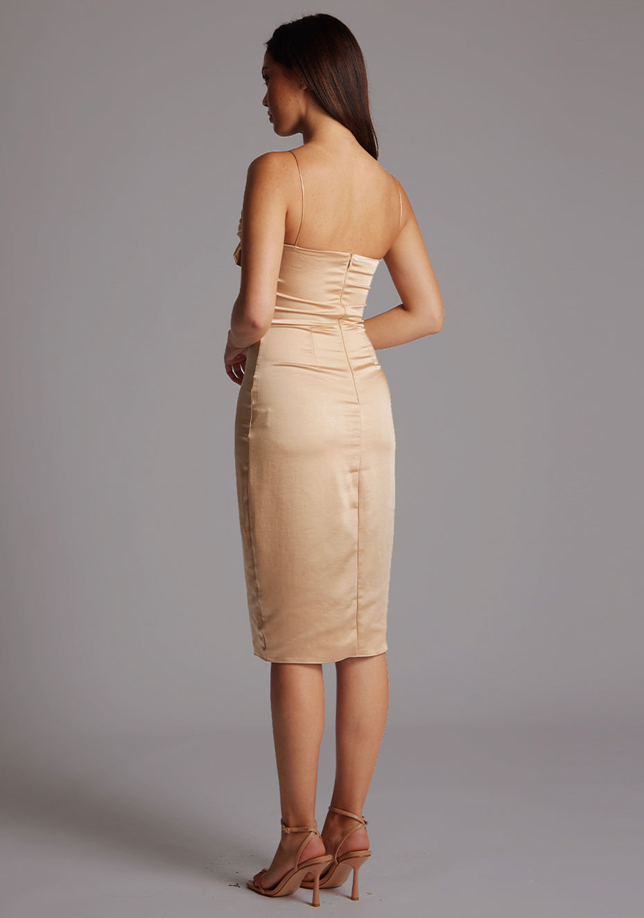 Side back image of a model wearing the Vesper Lisa Satin Midi Dress in Champagne on a model, showcasing the smooth fabric, elegant fit, and delicate strap detailing.