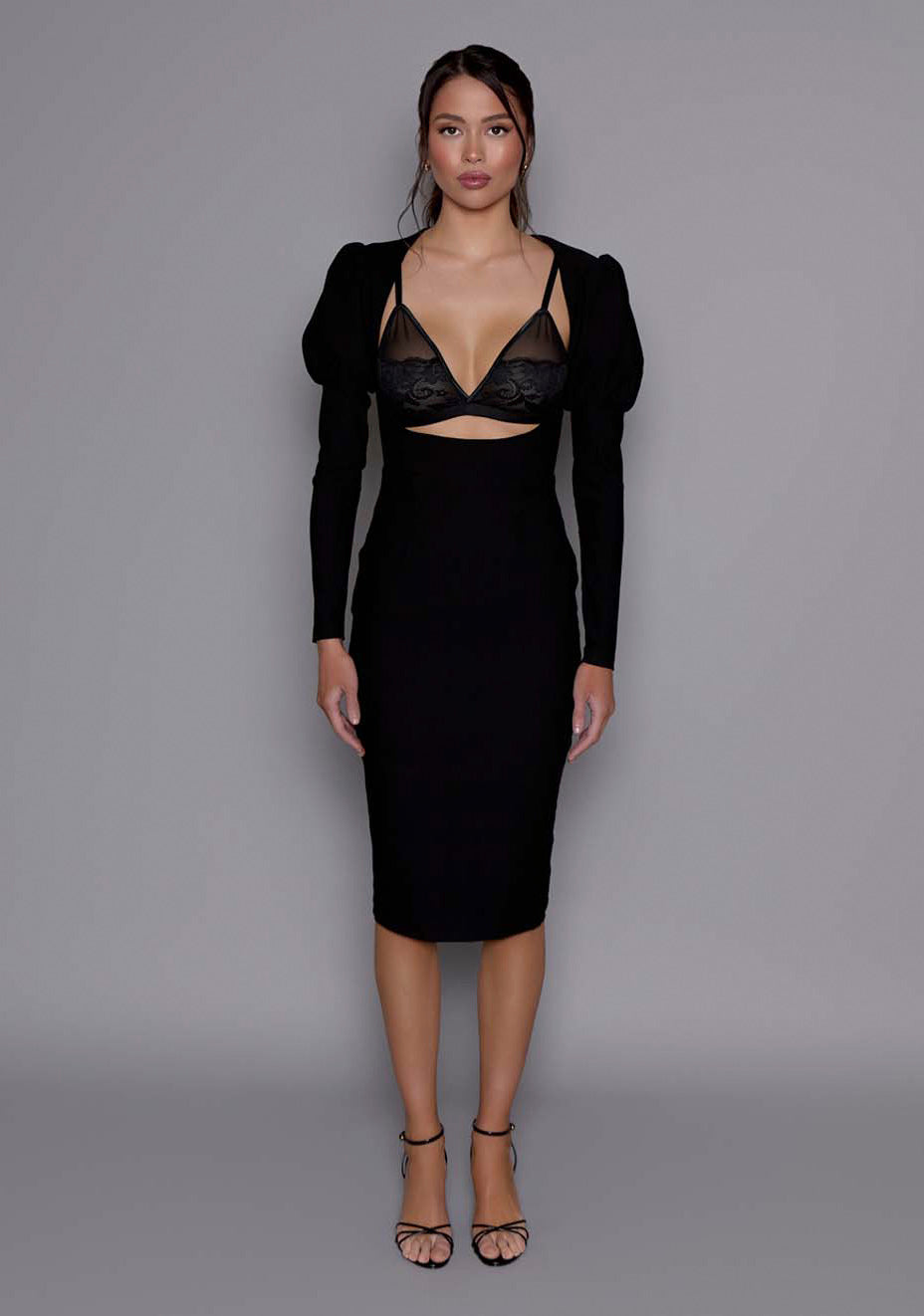 Model wearing the VSPR Lyra Sculpted Midaxi Dress in black, featuring a contoured bodice with strategic cut-outs, puffed shoulders, and long sleeves, against a neutral studio backdrop.
