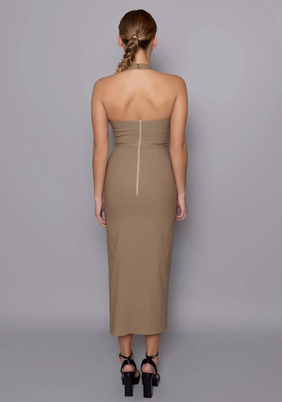 Back view of the VSPR Maria dress in taupe, showing the clean zipper closure, halterneck straps, and body-contouring fit that enhances the silhouette from behind.