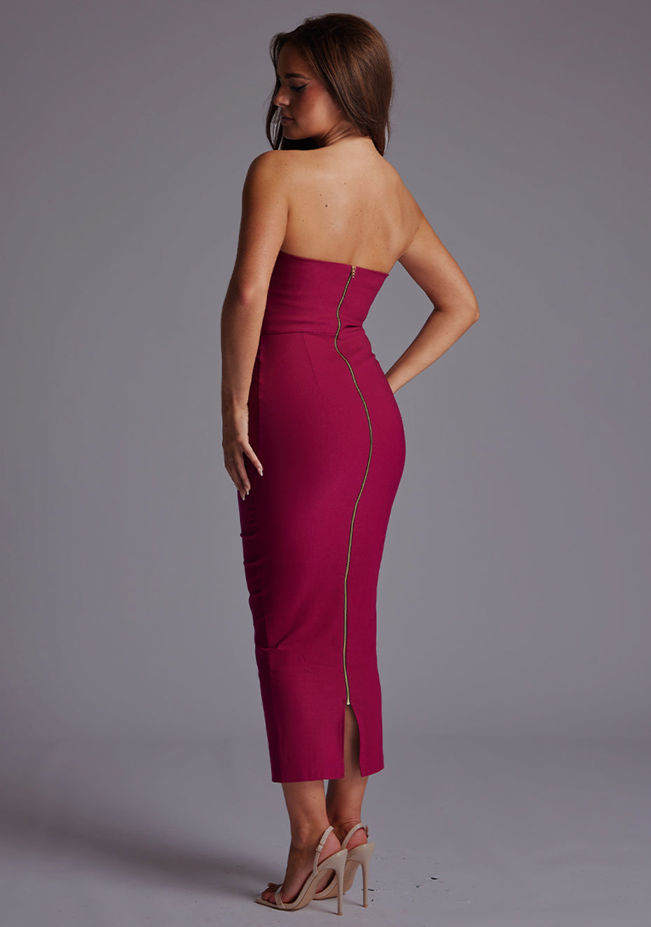 Side back image of a model wearing the Vesper Marion Sweetheart Neckline Midaxi Dress in Berry, highlighting the seamless fit, centre gold back zip and sculpted waist.