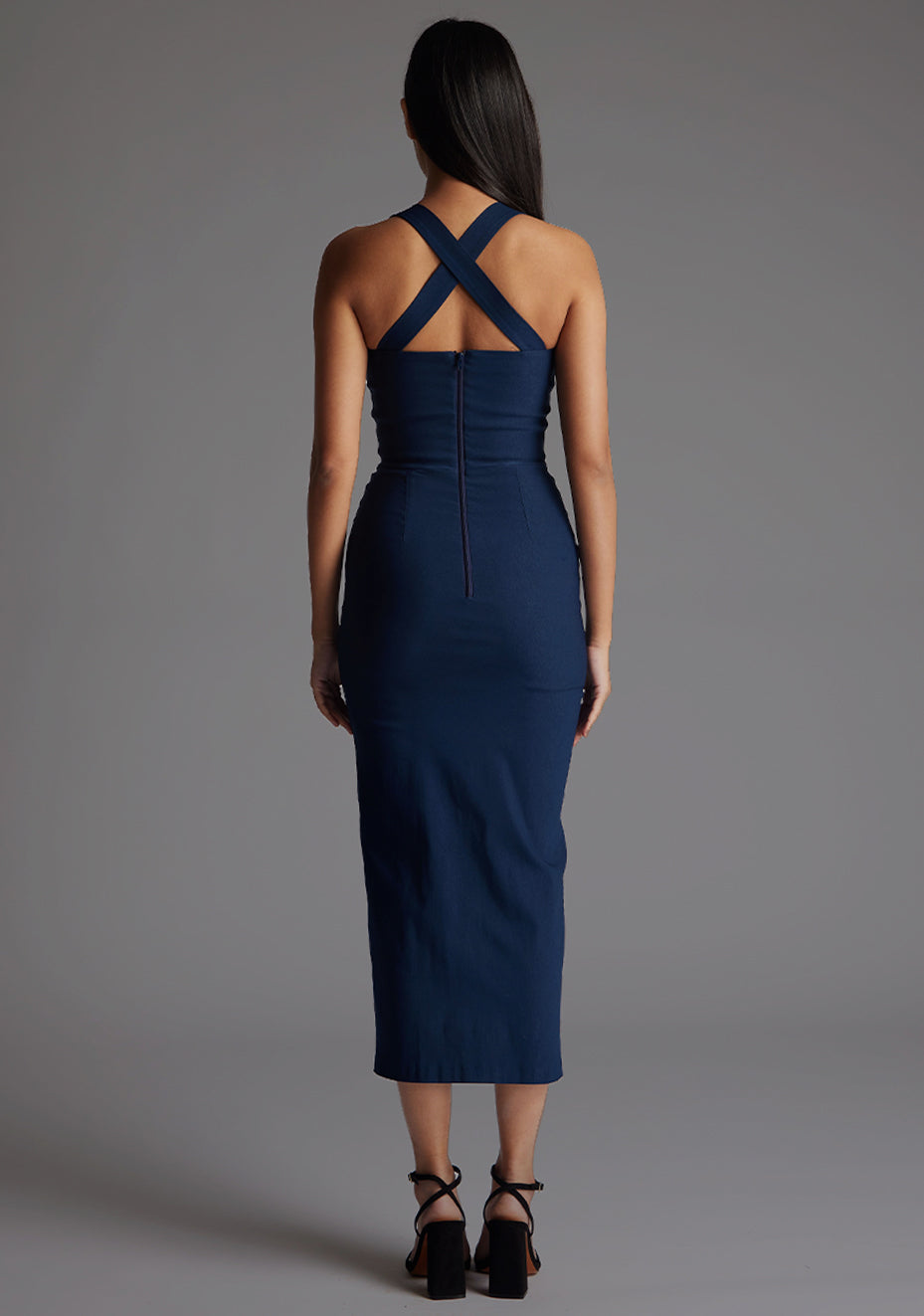 Back image of a model wearing the Vesper Nellie Notch Neck Midaxi Dress in Navy, showcasing the sleek back design and body-skimming silhouette.