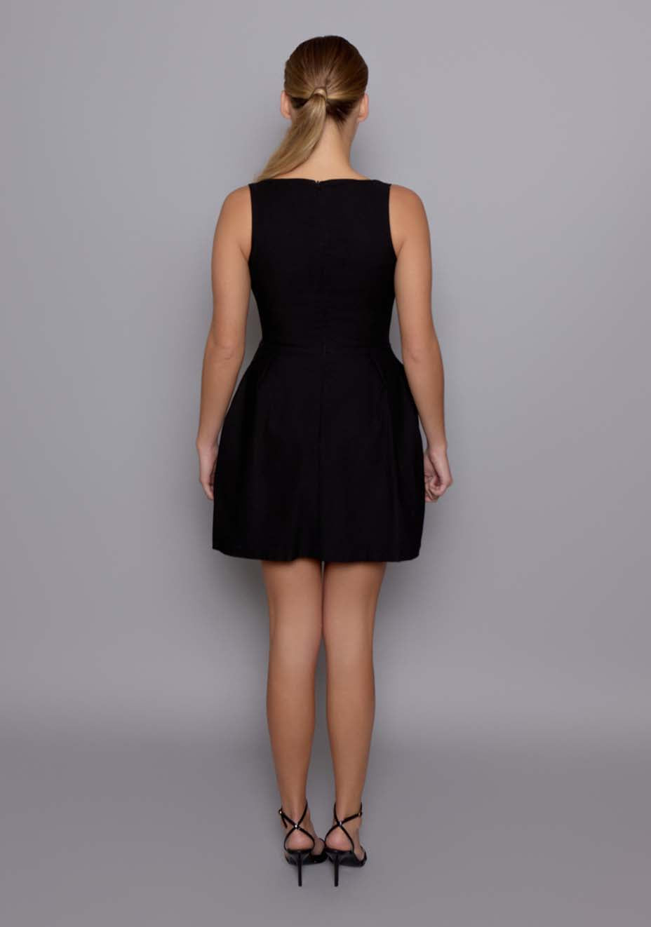 Back view of the VSPR Orla mini dress showing the translucent overlay revealing the structured mini skirt and coordinating lingerie set underneath, capturing the layered contrast and fitted back seam.