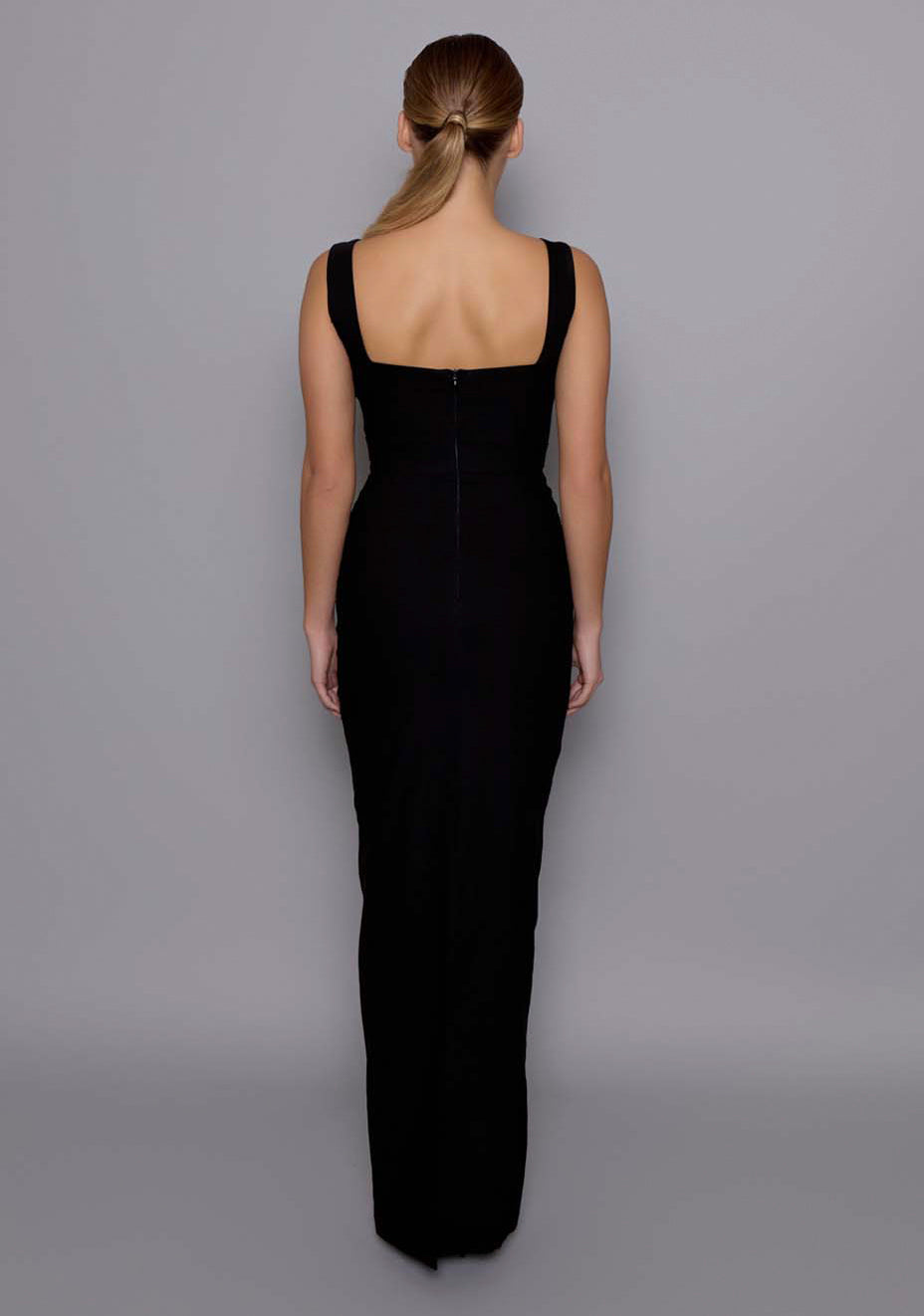Back view of the VSPR Solene black cut-out maxi dress featuring a sleek floor-length skirt, wide supportive straps, and a clean zip closure with subtle back detailing.