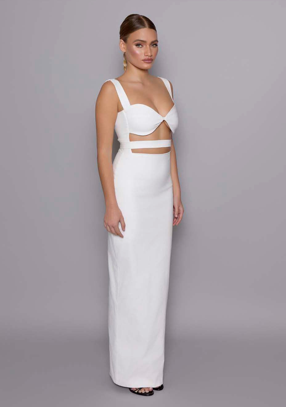 Side front view of the VSPR Solene ivory maxi dress with wide supportive straps, structured sweetheart neckline, and the elegant under-bust cut-out detailing, emphasizing the sculptural silhouette.