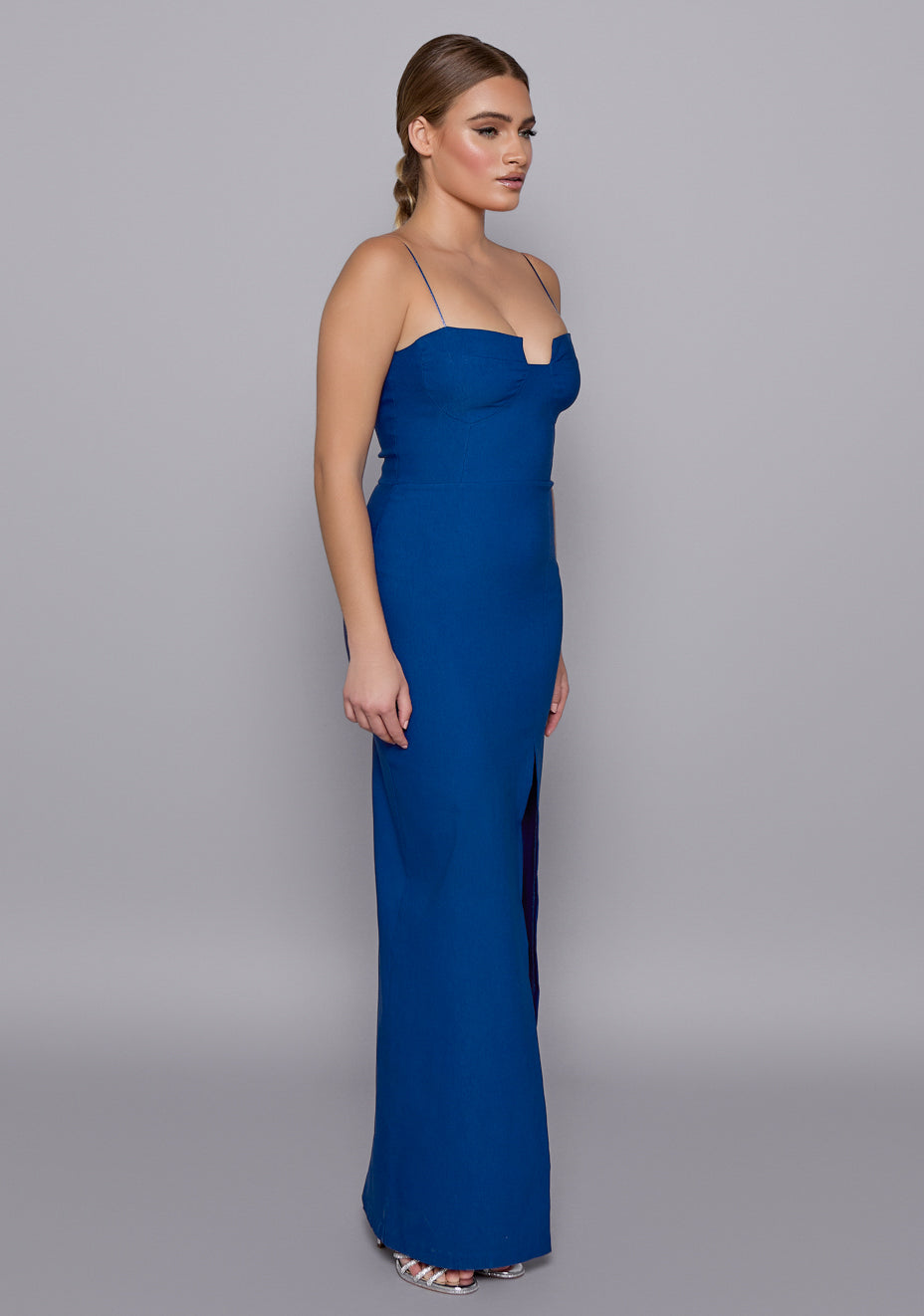 Side-front view of the VSPR Suki Cobalt Maxi Dress highlighting the flattering cut-out neckline, body-skimming silhouette, and thin modern straps.