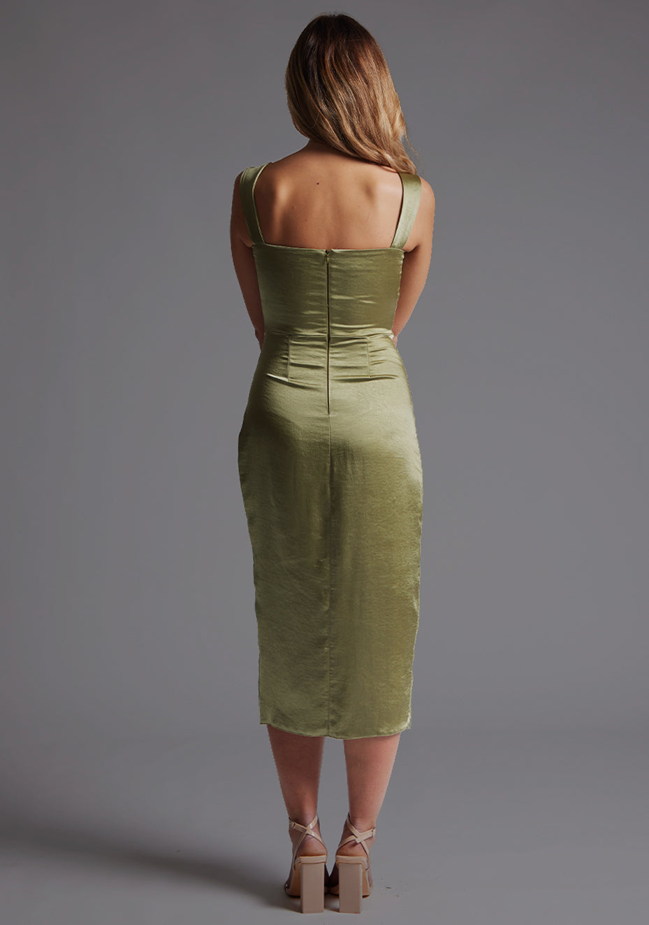 Back image of a model wearing olive satin midaxi dress with a sweetheart neckline, wide comfy straps and front skirt split. The dress featured is the Vesper Desiree Olive Satin Midaxi Dress.