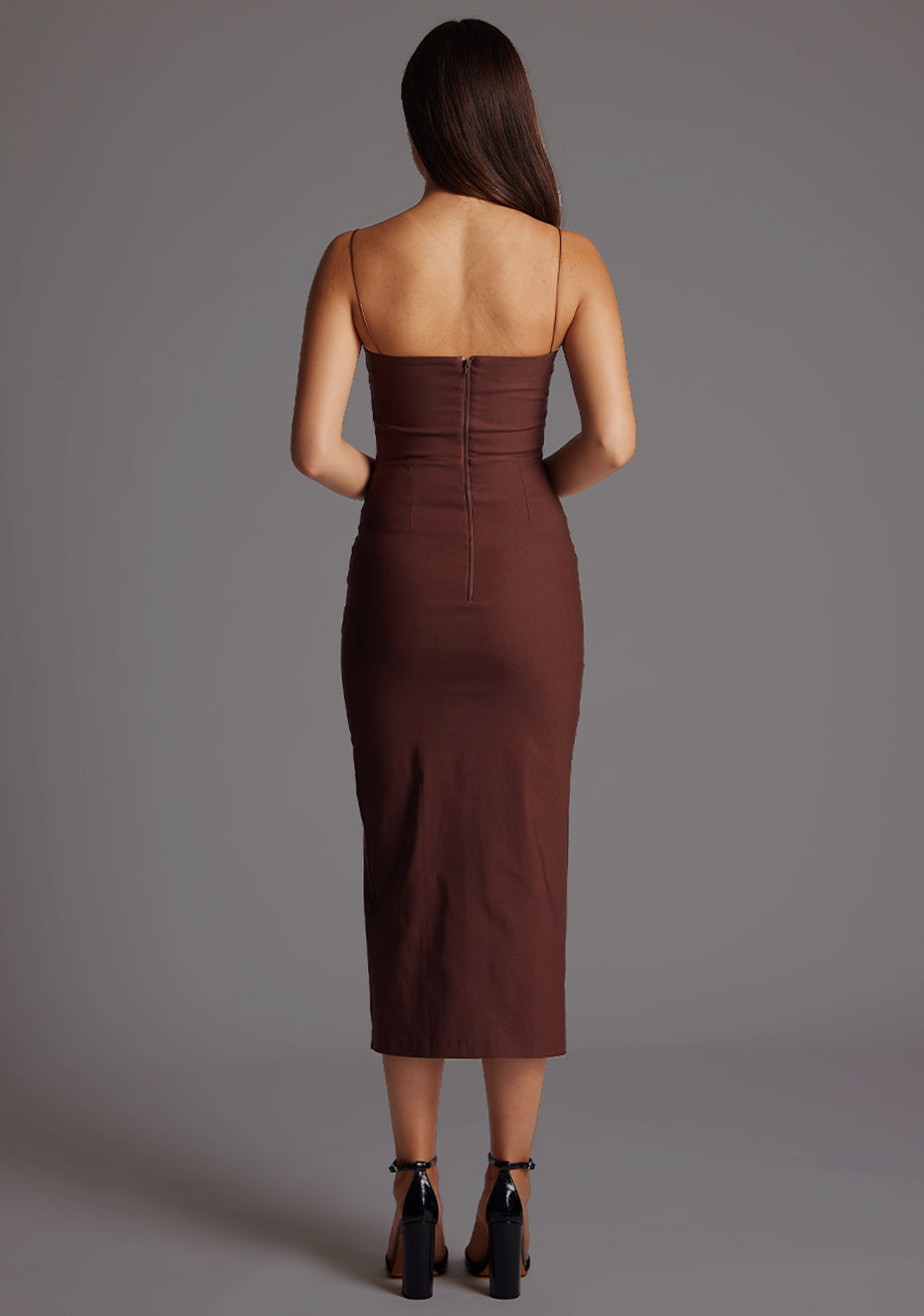 Back image of a model wearing a chocolate midaxi dress with a charming sweetheart neckline, front cut-outs for a sections at the bust and complete with a front skirt split for added movement. The design featured is the Vesper Kendall Chocolate Midaxi Dress