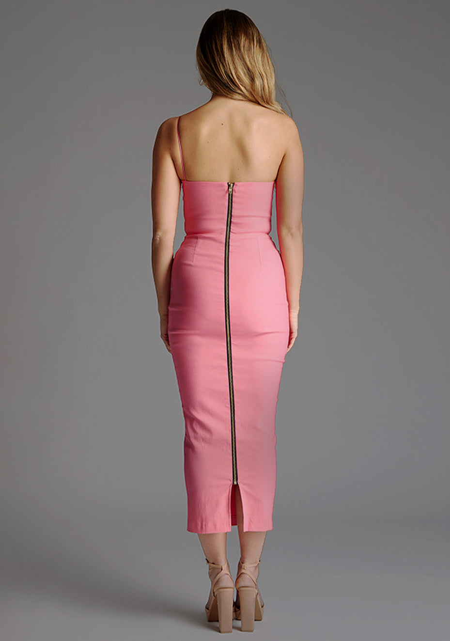 Back image of blonde model wearing a forest green midaxi dress with an alluring asymmetric design flatters every figure, while the bodycon silhouette accentuates your natural curves. The design feature is the Vesper Landen Fiesta Pink Dress.