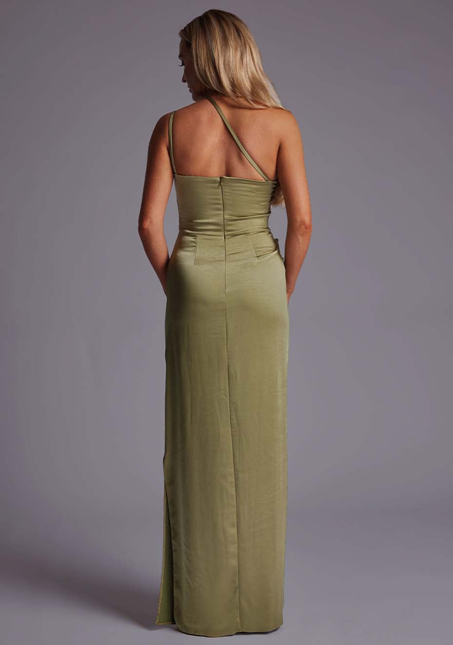 Back image of a model wearing an olive satin maxi dress with a cross strap detail, pleats detailing at the front bust and delicate side skirt split. The design featured is the Vesper Solange Olive Satin Maxi Dress.