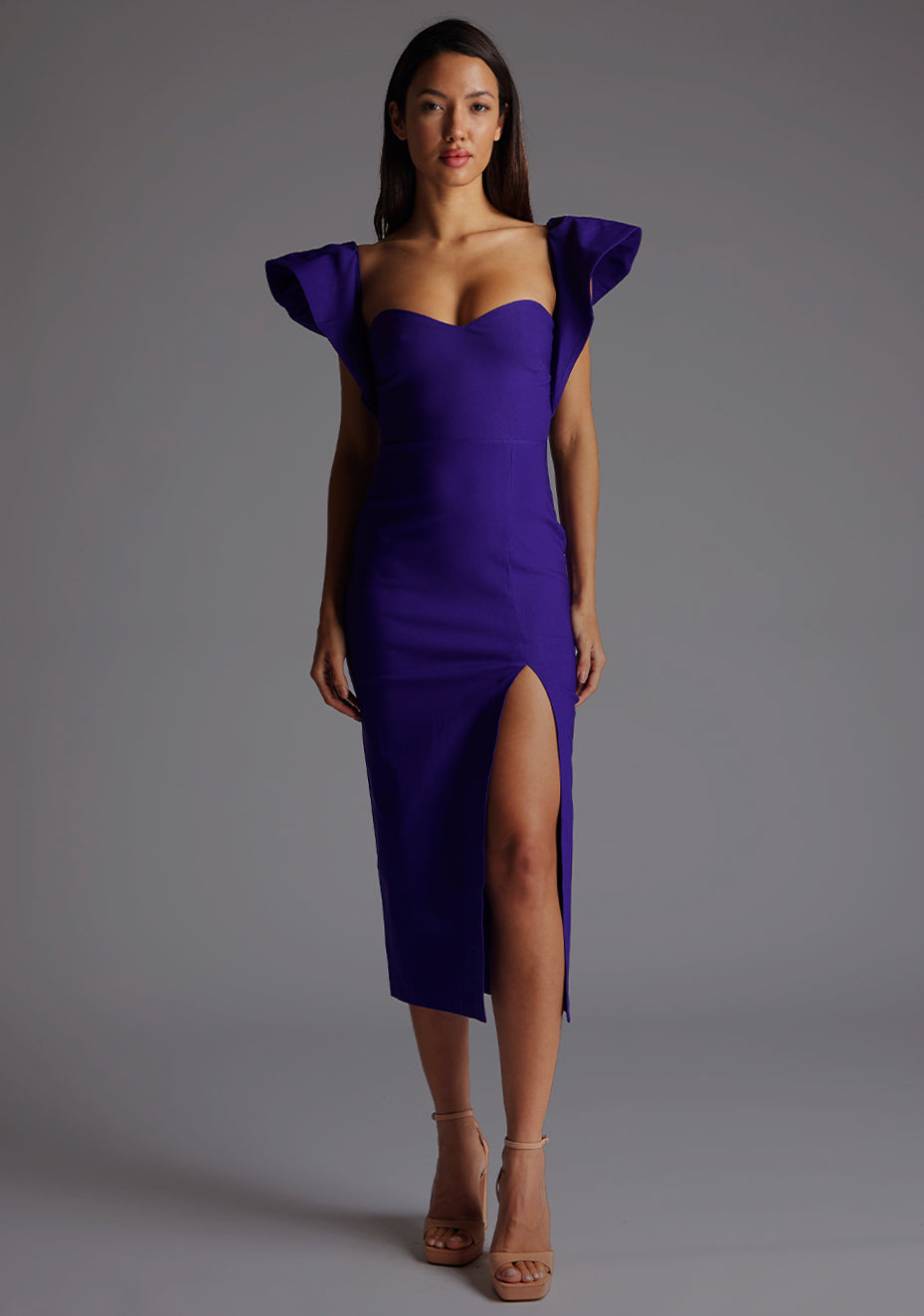 Front image of model wearing a purple frill sleeve midaxi Dress with a sweetheart neckline, short frill hem cap sleeves and a front skirt split. The design featured is the Vesper Sunday Purple Frill Sleeve Midaxi Dress.