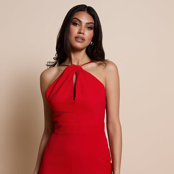 Close up image of a model wearing the amanda wide leg jumpsuit in red on a beige background
