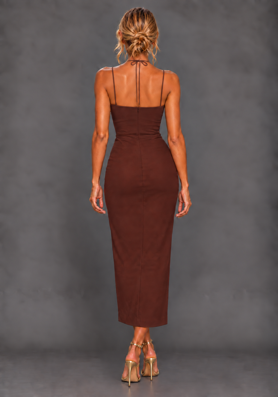Back image of a model wearing the VSPR Alyssa Strappy Thigh Split Chocolate Midaxi Dress, showcasing the sleek body-skimming silhouette and slender straps against a grey studio backdrop.