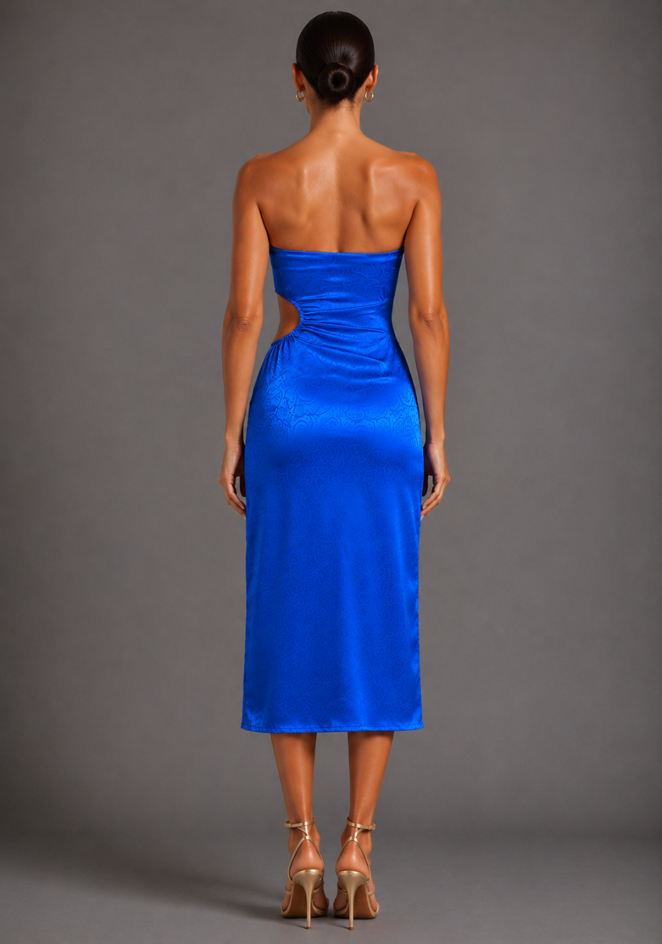 Back image of a model wearing the VSPR Eaden Bandeau Cut Out Cobalt Midaxi Dress, showing the clean strapless silhouette, elegant midaxi length, and smooth satin drape against a grey studio backdrop