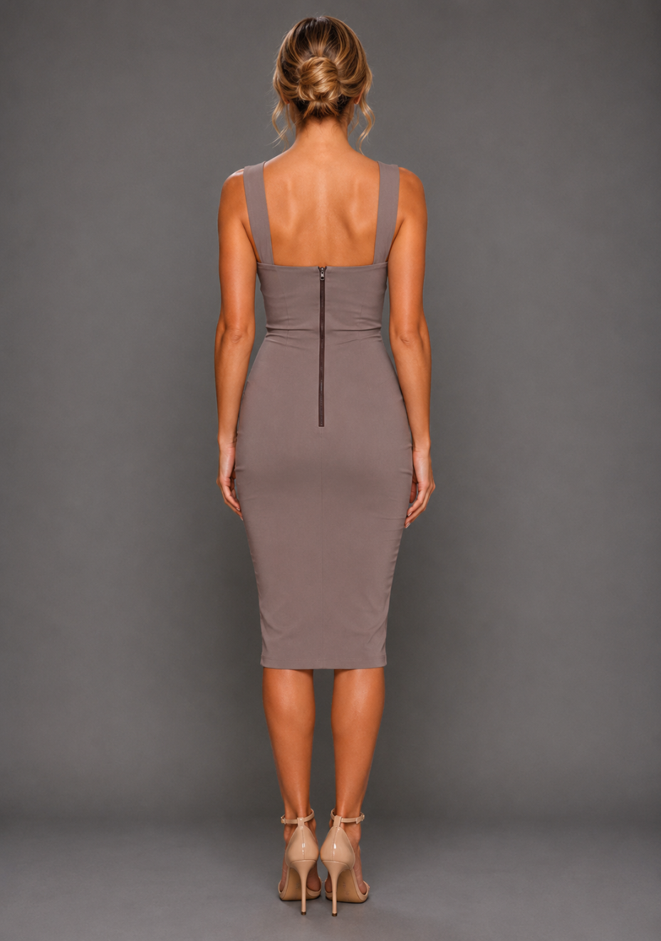 Back image of a model wearing the VSPR Isabelle Taupe Midaxi Dress, showcasing its sleek fitted silhouette and elegant midaxi length against a grey studio backdrop.