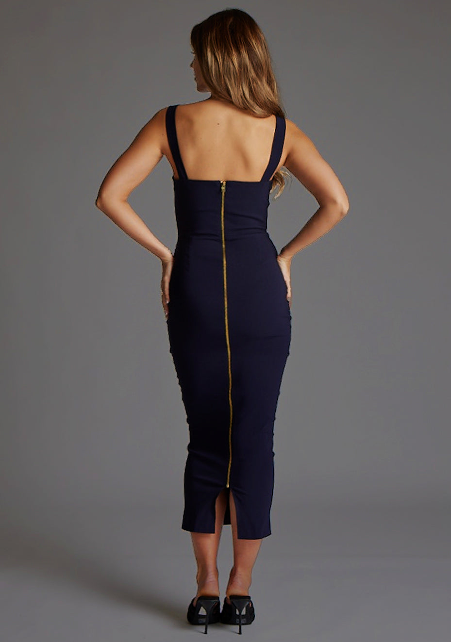 Back image of a model wearing an navy midaxi dress with a stunning sweetheart neckline and a flattering bodycon fit that accentuates your curves. The design featured is the Vesper Jennica Navy Midaxi Dress