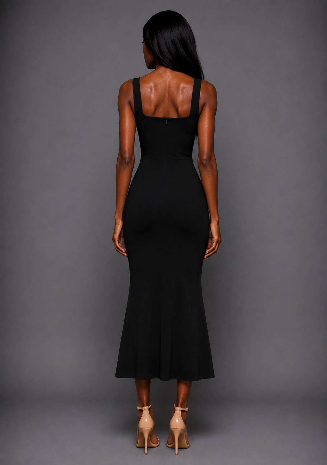 Back image of a model wearing the VSPR Marianna Square Neckline Fishtail Black Midaxi Dress featuring a clean back design, supportive wide straps, and elegant fishtail silhouette against a grey studio backdrop.