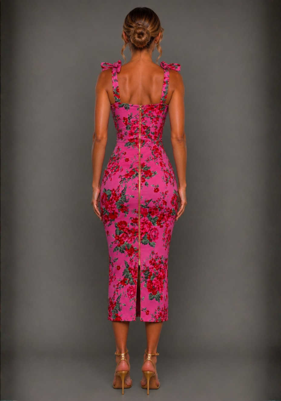 Back image of a model wearing the Vesper Soraya Bodycon Tie Strap Pink Floral Midaxi Dress highlighting the tie shoulder straps, fitted silhouette and midaxi length.