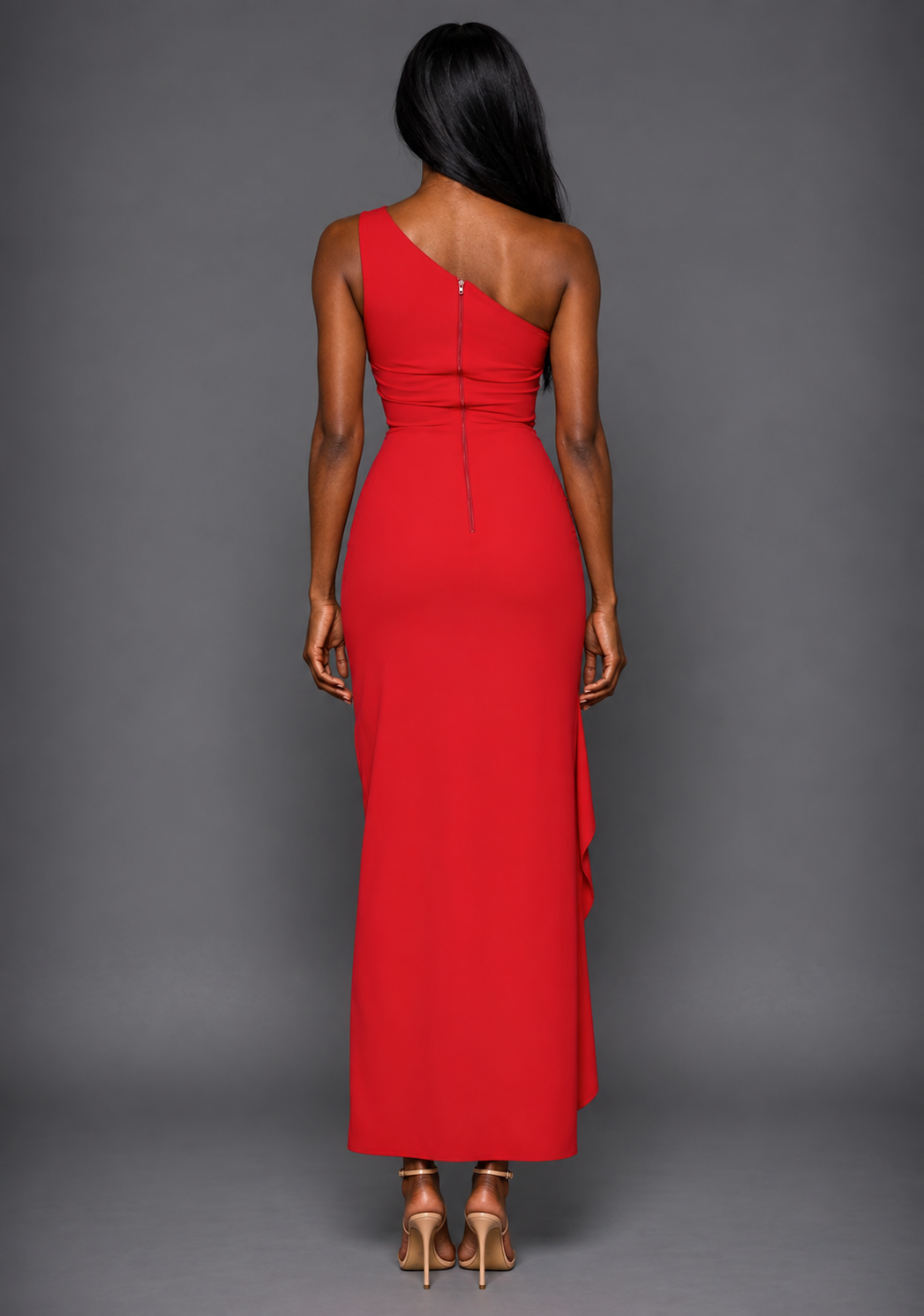 Back image of a model wearing the VSPR Stella One Shoulder Red Maxi Dress, showcasing asymmetric neckline, centre back zip, and sleek figure-enhancing silhouette and floor-length design against a grey studio backdrop