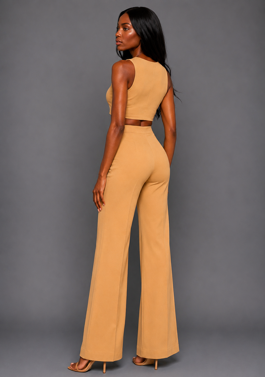 Side back image of a model wearing the VSPR Mia Square Neck Coffee Crop Top and matching VSPR Shea Coffee Wide Leg Trousers, showcasing the cropped back and high-rise wide-leg silhouette, standing against a grey studio backdrop.