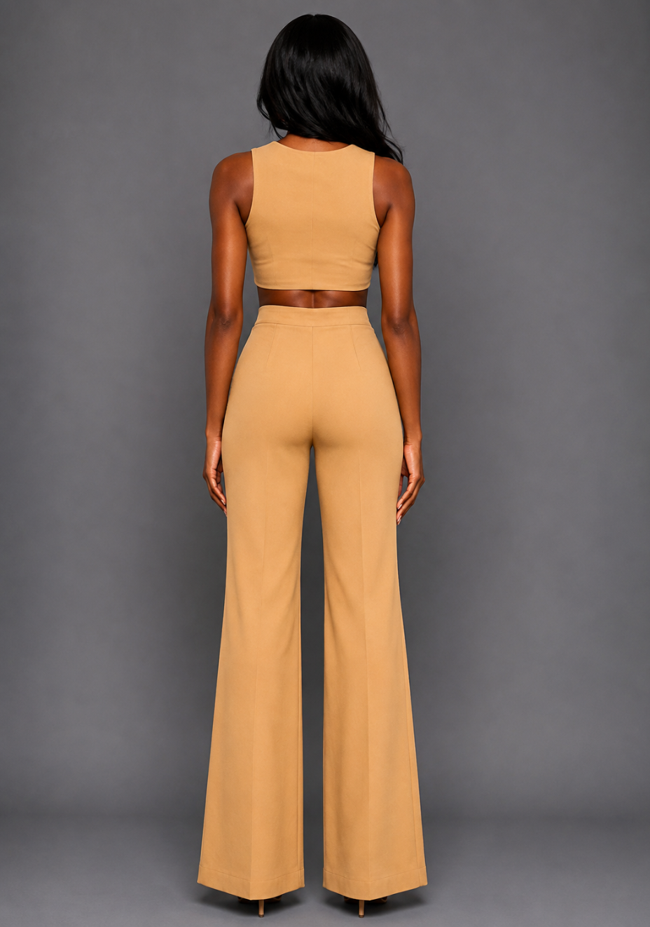 Back image of a model wearing the VSPR Mia Square Neck Coffee Crop Top and matching VSPR Shea Coffee Wide Leg Trousers, revealing the cropped back and wide-leg silhouette, standing against a grey studio backdrop.