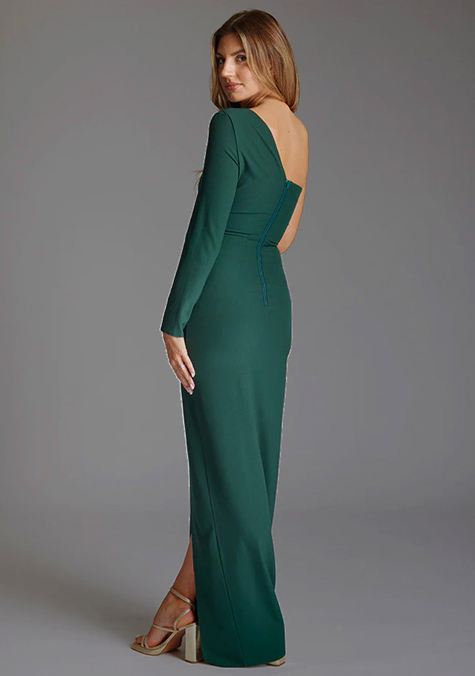 Side back image of a model wearing the Vesper Amellia One Sleeve Maxi Dress in Forest Green, revealing the clean back lines, smooth fit, and graceful maxi length.