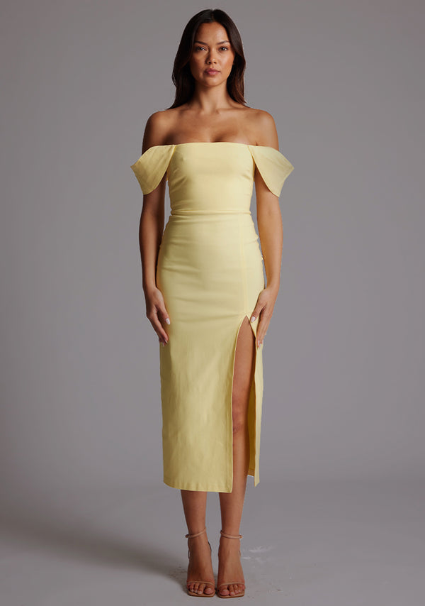 Front image of a model wearing a yellow Bardot midaxi dress with a stunning Bardot neckline, with armbands and a front skirt split. The design featured is the VSPR Astra Yellow Bardot Midaxi Dress.