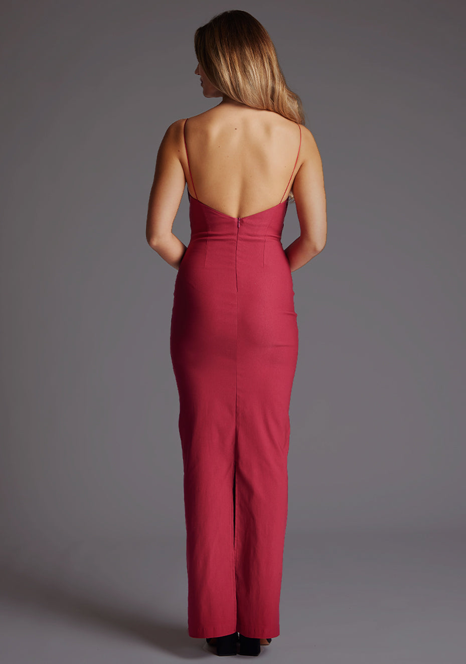 Back image of a model wearing  the Vesper Bellini Cami Strap Bow Maxi Dress in Raspberry, featuring a sleek open back design, delicate straps and timeless maxi shape.