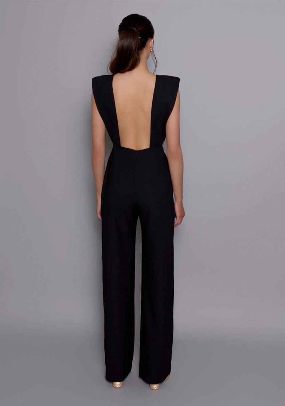  Back view of the VSPR Bronte Jumpsuit revealing the deep open back cut and sleek lines, emphasizing the contrast between bold tailoring and sensual design.