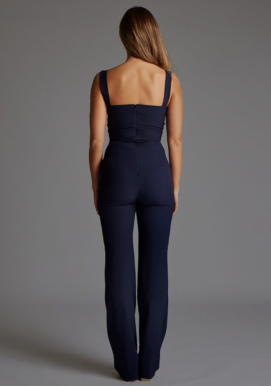 Back image of a model wearing the Vesper Collette Sweetheart Wide Leg Jumpsuit in Navy, highlighting the clean back design and fluid wide-leg trousers.