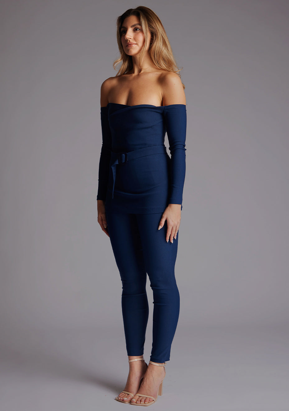 Side front image of a model wearing the Vesper Danica Slim Leg Tailored Trousers in Navy, showing the flattering high-rise waist and slim-leg line.