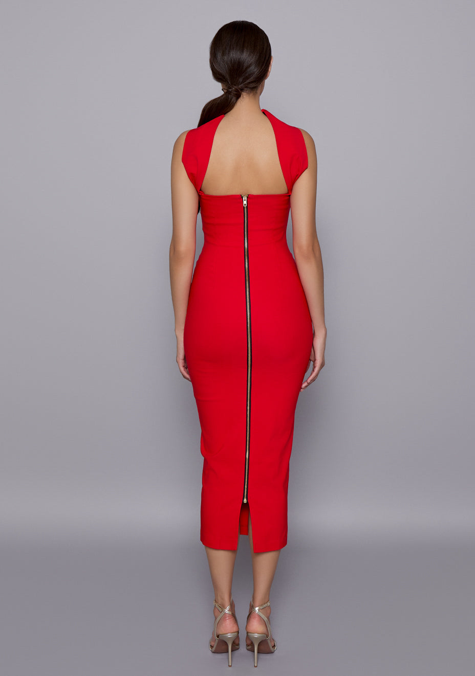 Back view of the VSPR Dion Dress revealing slim back strap detailing and a striking gold centre-back zip, emphasizing the clean lines and open-back structure.