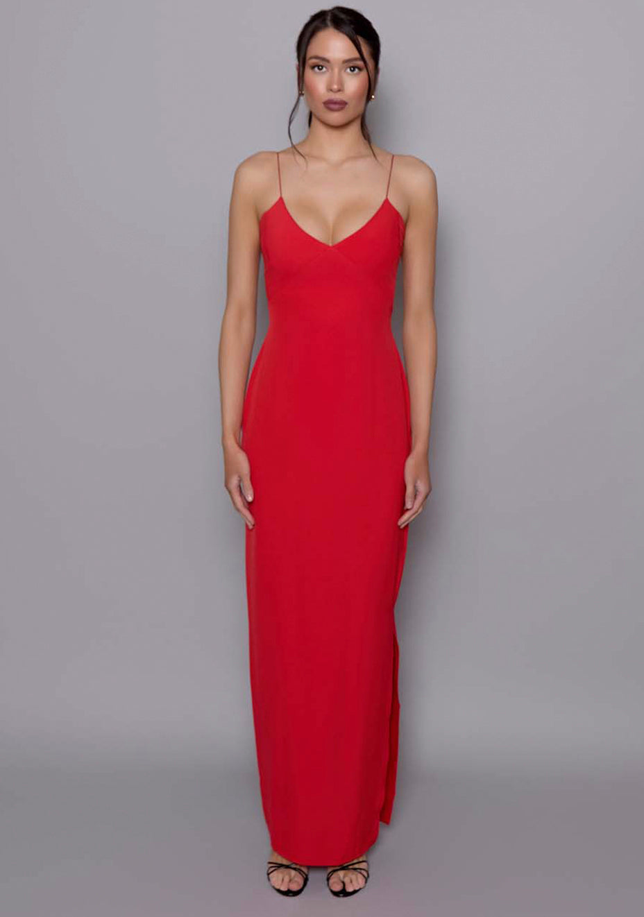 Model wearing the VSPR Ellesse scarlet red maxi dress with plunging neckline and spaghetti straps, showcasing the clean silhouette against a neutral studio backdrop.