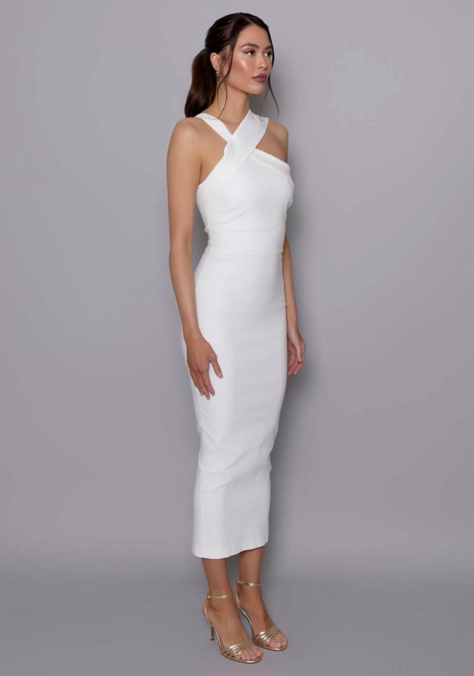 Side-front view of the VSPR Everest ivory midaxi dress showcasing the asymmetric neckline, sleek bodycon silhouette, and clean design lines that flatter the figure.